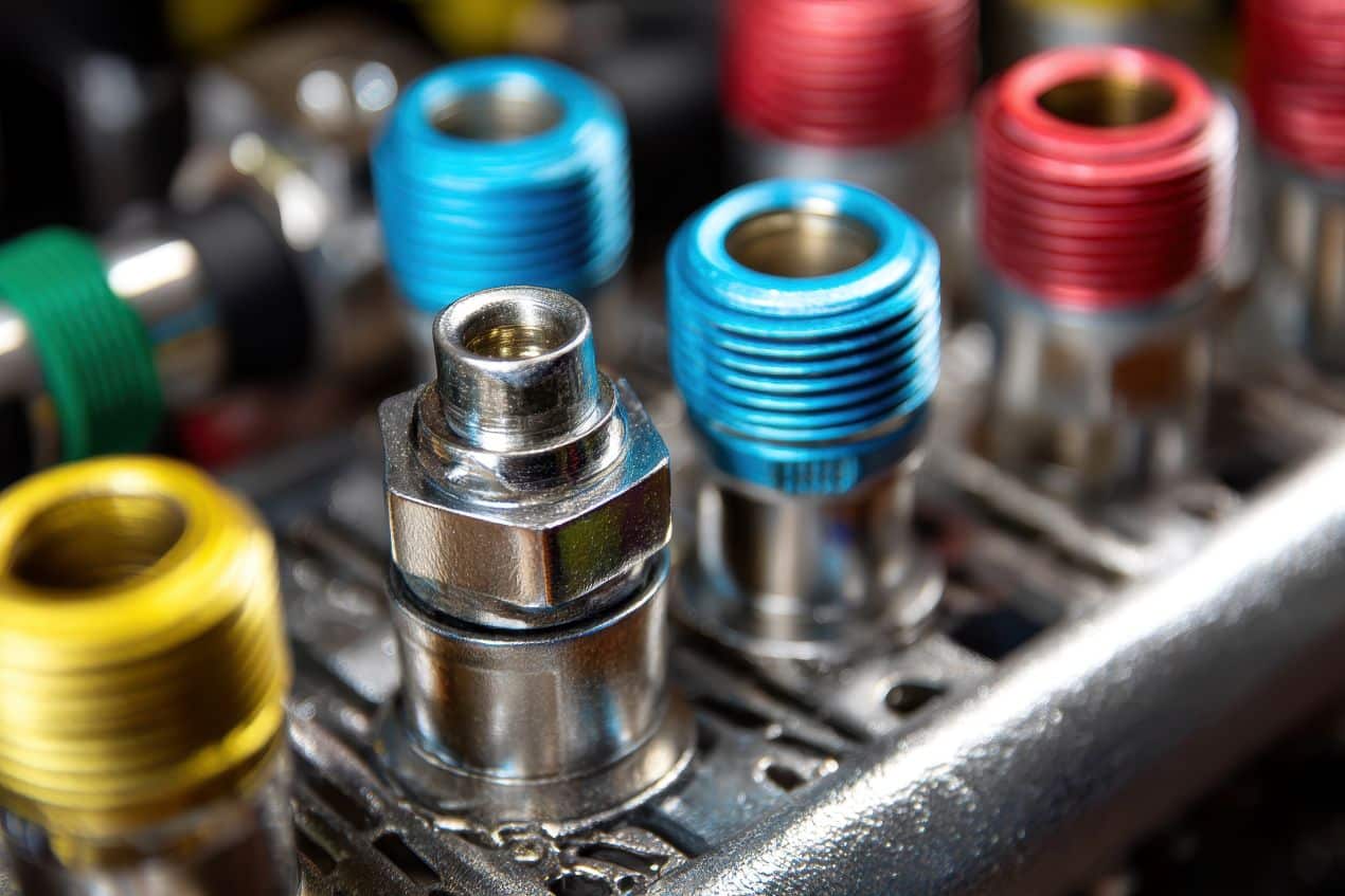 Mehrere farblich gekennzeichnete Hydraulik Kupplungen und Anschluesse in Nahaufnahme auf einer technischen Arbeitsfläche