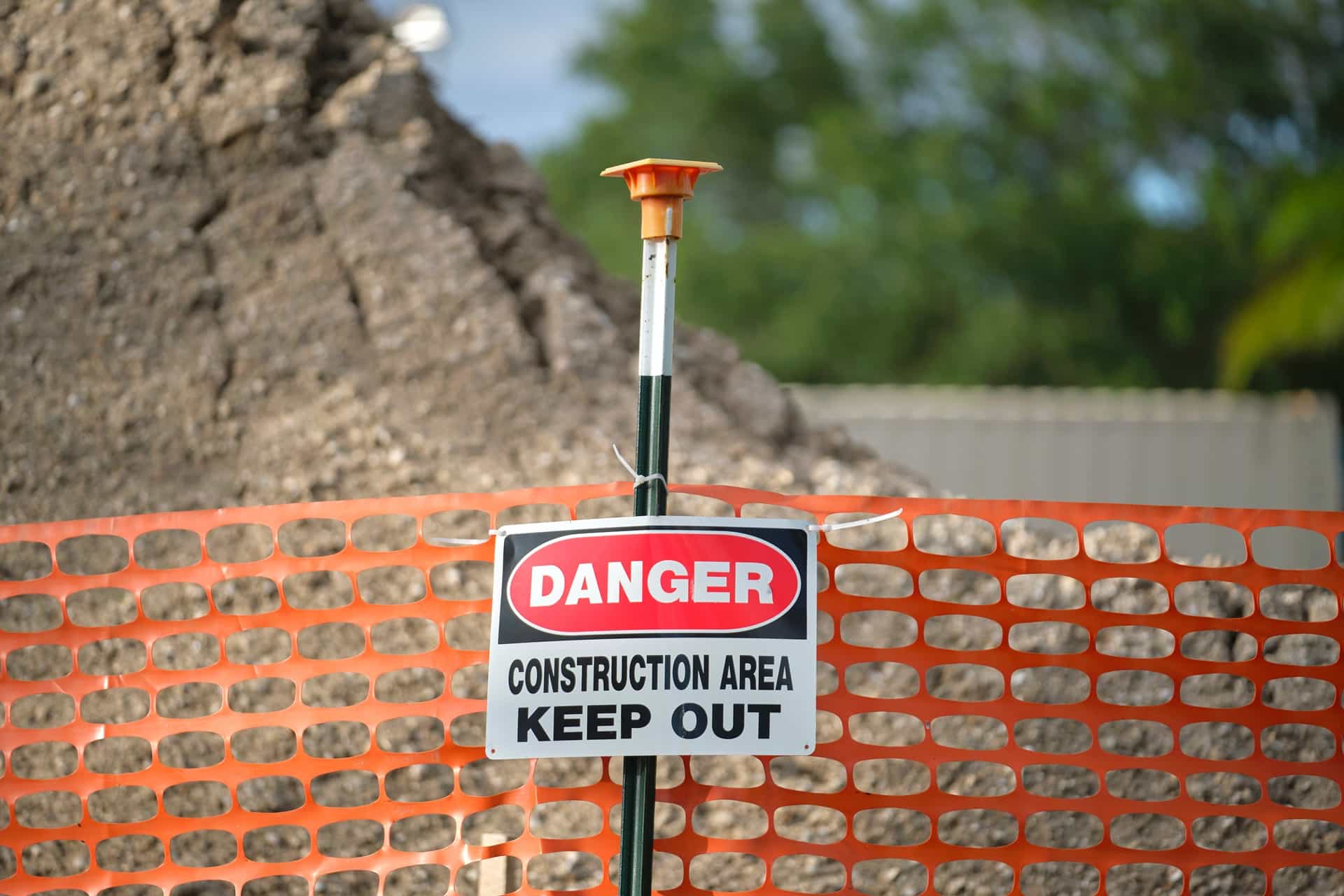 Warnschild 'Danger Keep Out' an orangefarbenem Netz | Bauzaun