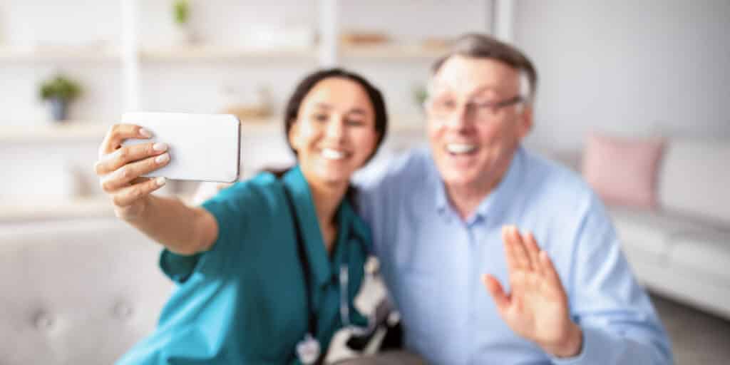 Pflegekraft macht Selfie mit Senior