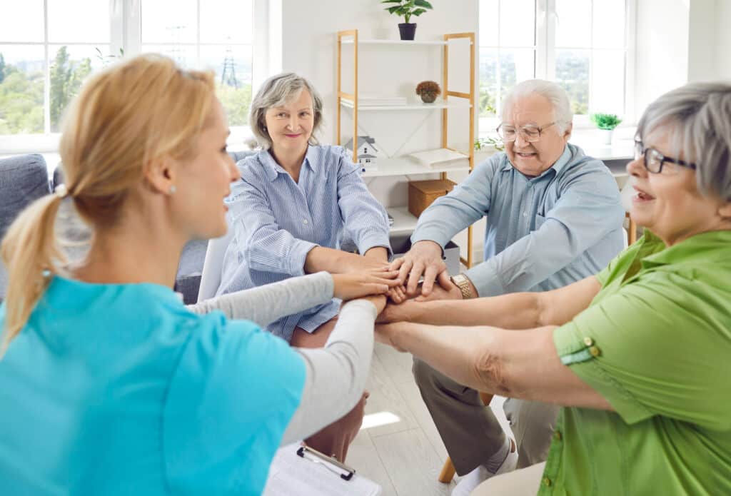 Seniorengruppe mit Pflegekraft im Gespräch